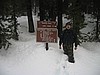 25. Ken at the Barker Pass sign. Thigh high snow..jpg